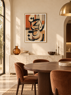 Terracotta Script: terracotta and charcoal abstract Arabic calligraphy, displayed in a slim gold frame in a styled interior.
