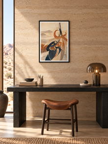 Desert Flow: sand-toned flowing Arabic-inspired abstract art, displayed in a slim black frame in a styled interior.
