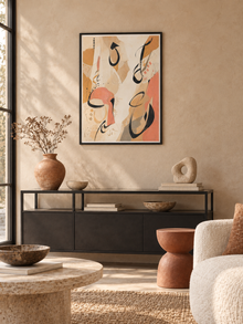 Sand Gesture: loose Arabic-inspired marks over sand and peach abstract shapes, displayed in a slim black frame in a styled interior.