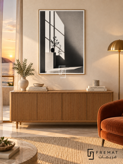 Window Light by FREMAT: window shadows and a vase in a gold PVC frame with a printed white border, displayed in a styled interior.
