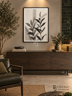 Botanical Shadow by FREMAT: botanical leaves and shadows in a black PVC frame with a printed white border, displayed in a styled interior.