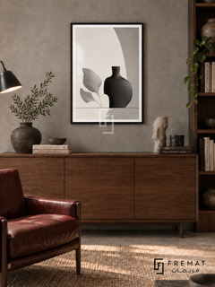 Quiet Vessel by FREMAT: a sculptural vase and leaves in a black PVC frame with a printed white border, displayed in a styled interior.
