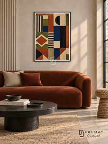 Woven Rhythm by FREMAT in a matte black PVC frame with a flat white printed border. Modern craft loft: pale plaster wall with deep vertical fluted section at left, 160cm rust velvet loveseat below artwork, blackened steel coffee table, grey limestone floor, broad indirect daylight, sculptural rope stool at right.