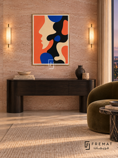 Coral Profile by FREMAT in a champagne gold PVC frame with a flat white printed border. Elegant private salon: blush-pink travertine slab wall, 150cm ebonized console with curved legs, olive velvet accent chair right, black marble oval side table, linen rug, warm sconces outside artwork area and twilight window.