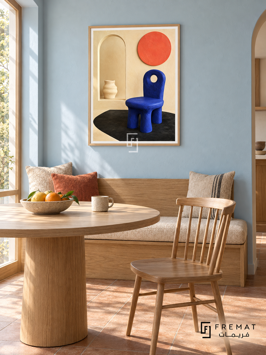 Cobalt Chair by FREMAT in a light natural wood PVC frame with a flat white printed border. Designer breakfast nook: pale blue chalk-painted wall, 145cm oak banquette with beige wool cushion beneath art, round natural ash table in foreground and simple spindle chair right, warm clay tile floor, morning window light and ceramic fruit dish.