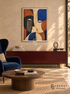 Two Faces by FREMAT in a champagne gold PVC frame with a flat white printed border. Intimate modern salon: warm ivory limestone wall with large staggered slabs, 150cm oxblood lacquer sideboard, deep blue wingback chair left, round walnut cocktail table, tan woven rug and filtered late-afternoon light.