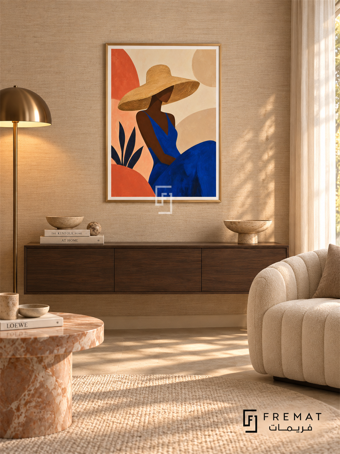 Sun Hat by FREMAT in a champagne gold PVC frame with a flat white printed border. Resort-inspired salon: natural flax grasscloth wall, 150cm dark walnut floating console, ivory channel-tufted chair right, pink marble pedestal table, warm cream rug, gauzy afternoon daylight and shaded brass floor lamp.
