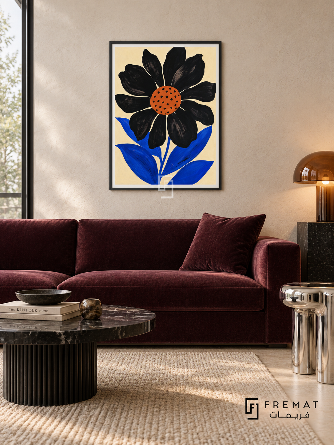 Graphic Flower by FREMAT in a matte black PVC frame with a flat white printed border. Bold modern botanical lounge: ivory plaster wall, 155cm aubergine velvet sofa, black marble low table with fluted cylinder base, chrome stool right, neutral wool rug, broad overcast daylight and amber glass lamp.