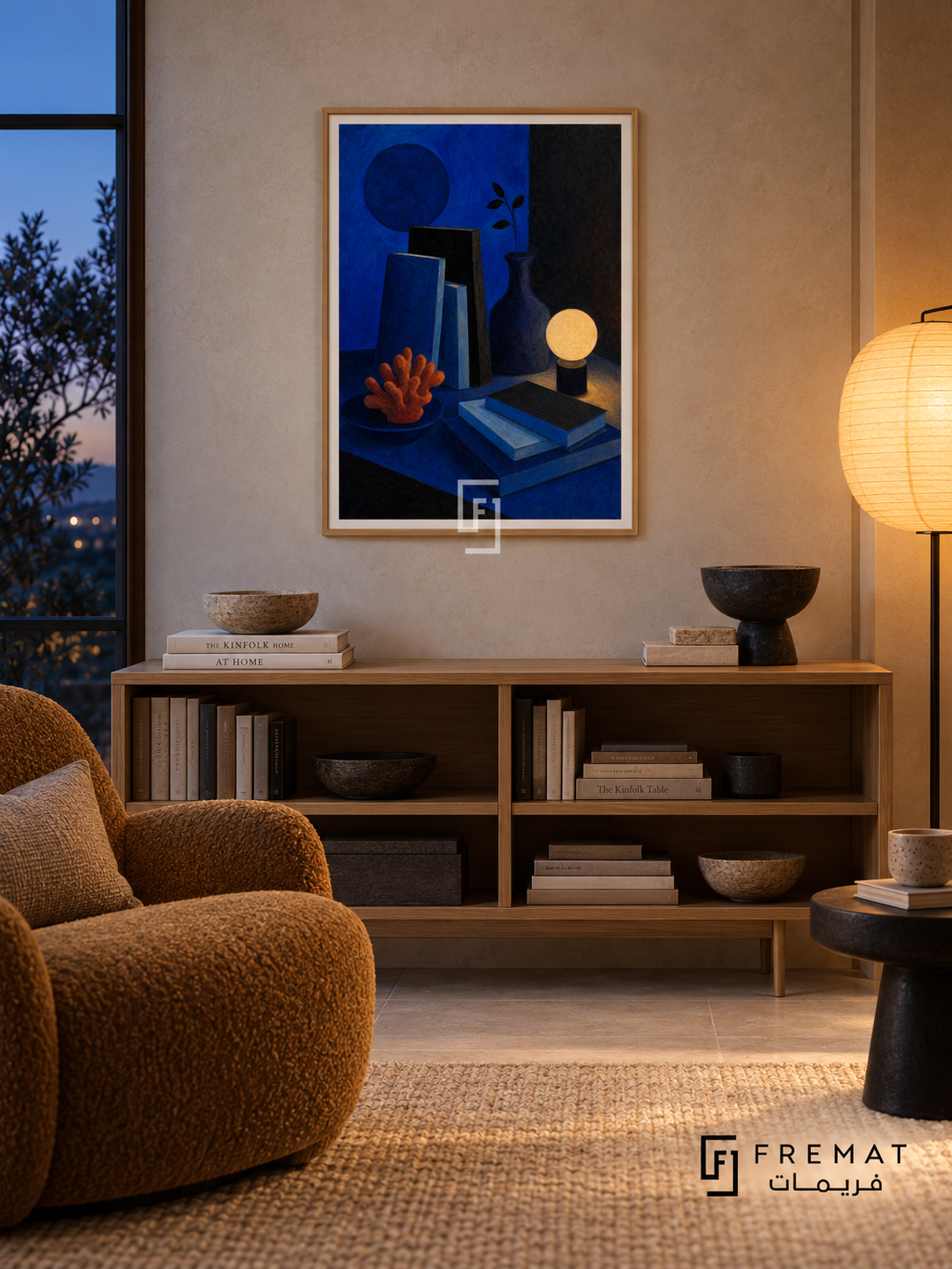 Night Table by FREMAT in a light natural wood PVC frame with a flat white printed border. Evening book nook: pale stone limewash wall, 150cm natural oak book cabinet, ochre woven lounge chair left, small black ceramic side table right, oatmeal rug, amber paper lantern glow balanced by blue-hour window light.