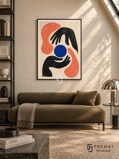 Graphic Hands by FREMAT in a matte black PVC frame with a flat white printed border. Contemporary art-library nook: warm-white painted brick wall, 160cm olive wool bench sofa, black steel bookshelf cropped left, glass side table right, taupe carpet, raking skylight and chrome mushroom lamp.