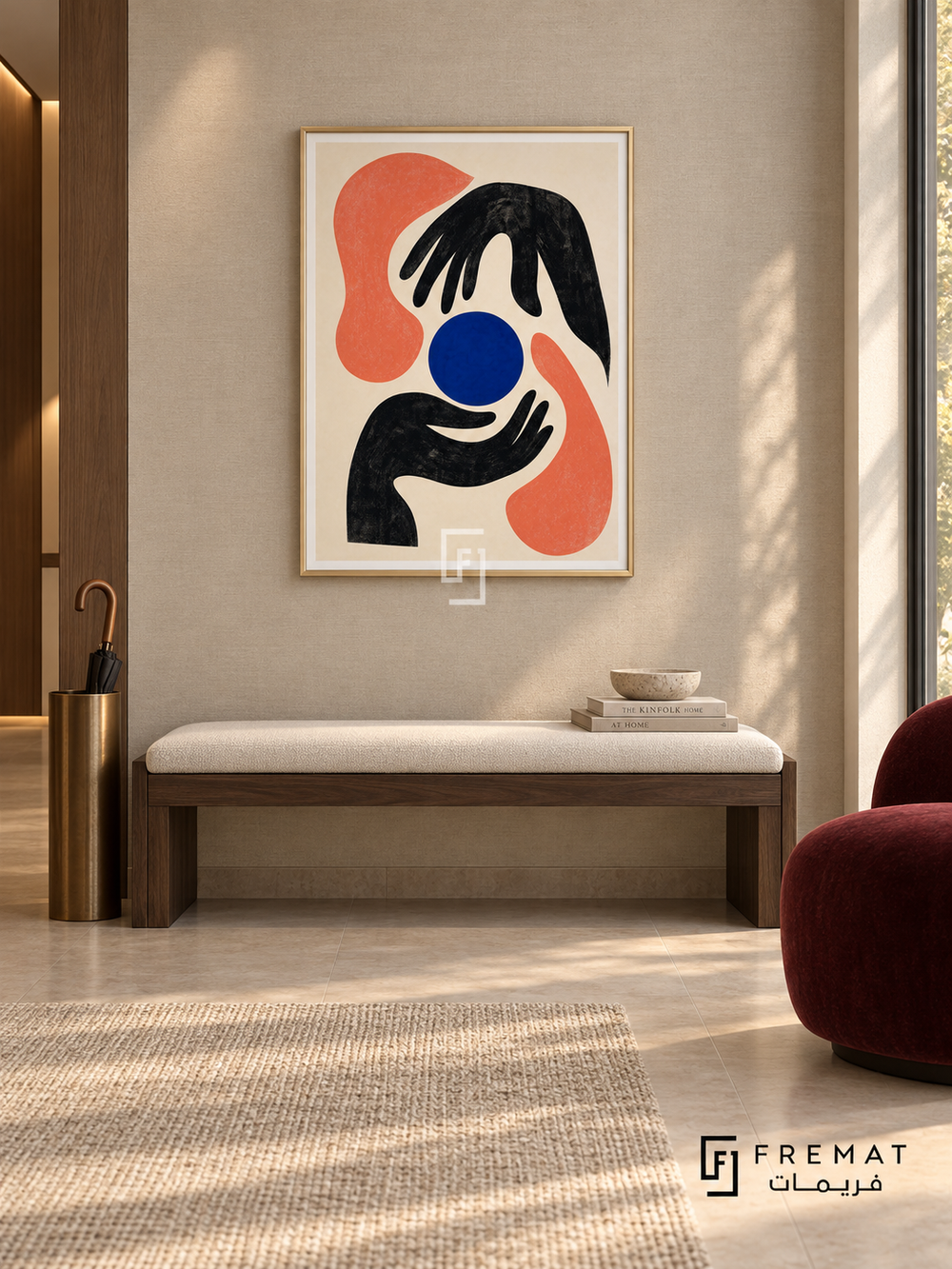 Graphic Hands by FREMAT in a champagne gold PVC frame with a flat white printed border. Curated modern foyer: pale taupe linen-textured wall, 150cm dark walnut bench with ivory cushion, bronze umbrella stand at far left, burgundy armless chair right, beige stone floor, soft wall-wash lighting and afternoon window.