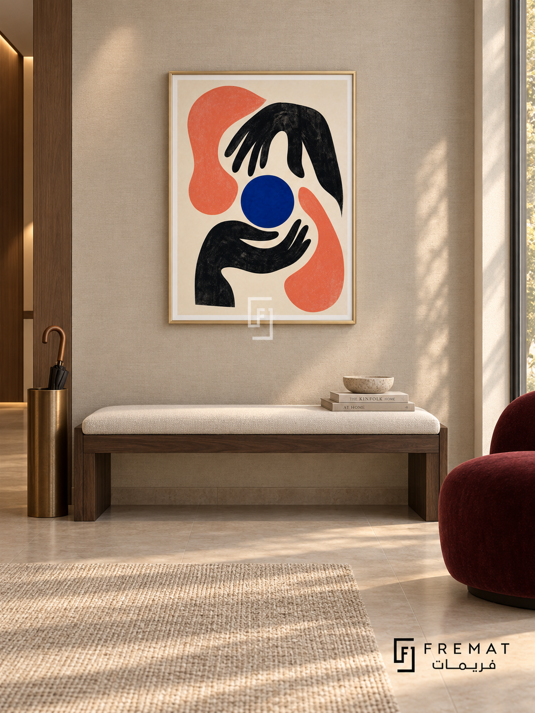 Graphic Hands by FREMAT in a champagne gold PVC frame with a flat white printed border. Curated modern foyer: pale taupe linen-textured wall, 150cm dark walnut bench with ivory cushion, bronze umbrella stand at far left, burgundy armless chair right, beige stone floor, soft wall-wash lighting and afternoon window.