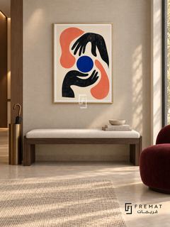 Graphic Hands by FREMAT in a champagne gold PVC frame with a flat white printed border. Curated modern foyer: pale taupe linen-textured wall, 150cm dark walnut bench with ivory cushion, bronze umbrella stand at far left, burgundy armless chair right, beige stone floor, soft wall-wash lighting and afternoon window.