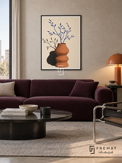 Bright Vase by FREMAT in a matte black PVC frame with a flat white printed border. Urban color collector lounge: pale putty microcement wall, 160cm deep plum sofa, polished black oval table, chrome tubular chair right, grey wool rug, diffuse cool light and warm terracotta dome lamp.