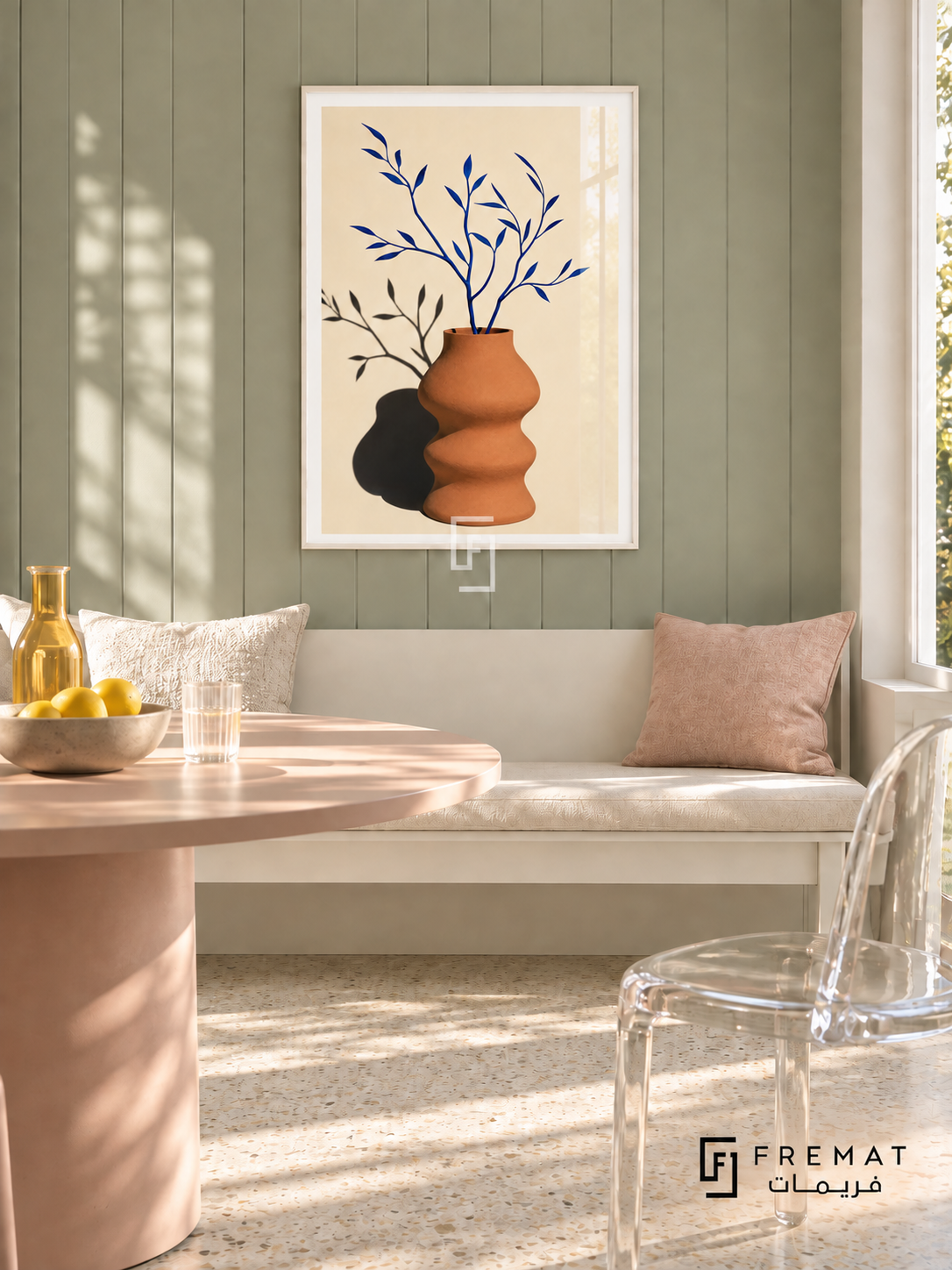 Bright Vase by FREMAT in a satin white PVC frame with a flat white printed border. Playful elegant breakfast room: pale sage board-and-batten wall, 150cm satin-white bench, blush round dining table partly visible left, clear acrylic chair right, cream terrazzo floor, cloud daylight and simple yellow glass bottle.