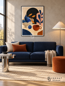 Playful Still Life by FREMAT in a matte black PVC frame with a flat white printed border. Graphic urban reading alcove: warm light-grey concrete wall, 160cm navy wool sofa, chrome side table left, burnt-orange low stool right, cream rug on oak, broad window light and white conical lamp.