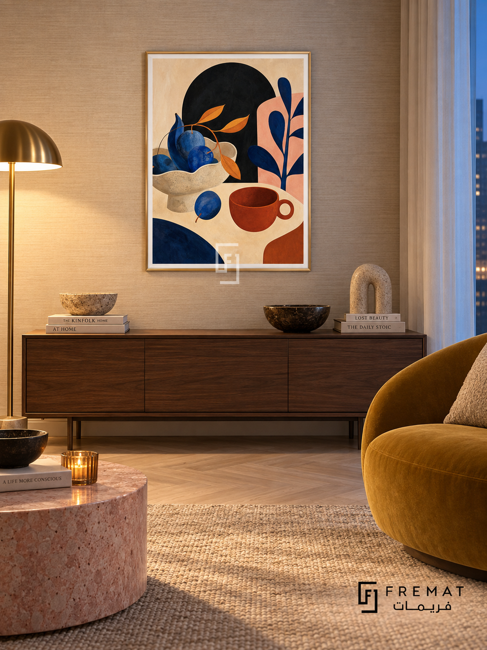 Playful Still Life by FREMAT in a champagne gold PVC frame with a flat white printed border. Artful evening apartment: pale champagne grasscloth wall, 150cm deep walnut cabinet, mustard velvet chair right, pink stone cylinder table, pale parquet, warm floor-lamp pool and cool blue-hour curtain light.