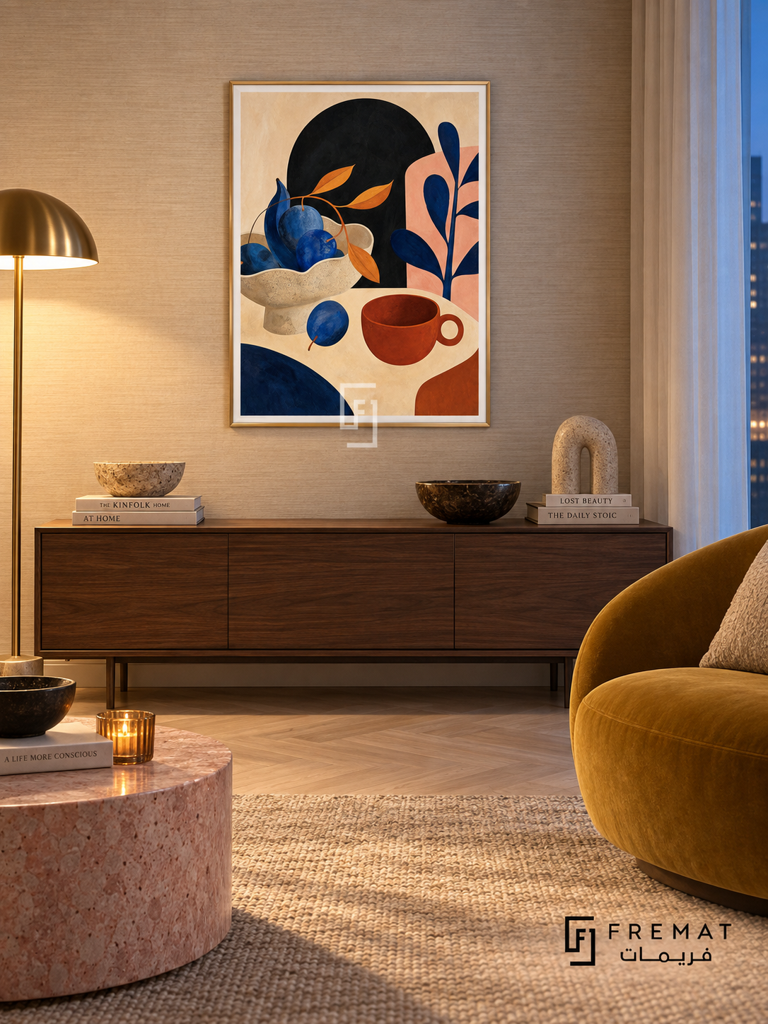 Playful Still Life by FREMAT in a champagne gold PVC frame with a flat white printed border. Artful evening apartment: pale champagne grasscloth wall, 150cm deep walnut cabinet, mustard velvet chair right, pink stone cylinder table, pale parquet, warm floor-lamp pool and cool blue-hour curtain light.