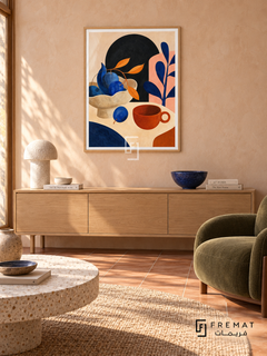 Playful Still Life by FREMAT in a light natural wood PVC frame with a flat white printed border. Playful ceramics lounge: pale peach tadelakt wall, 150cm blond oak sideboard, olive canvas lounge chair right, round white terrazzo table, terracotta square floor, soft morning sun and cobalt ceramic bowl.