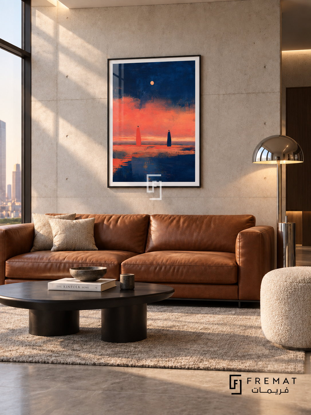 Evening Figures by FREMAT in a matte black PVC frame with a flat white printed border. Architectural city lounge: pale concrete wall with fine formwork lines, 160cm cognac leather sofa, asymmetrical black table, cream boucle stool at right, grey stone floor, clerestory lighting and sculptural chrome lamp.