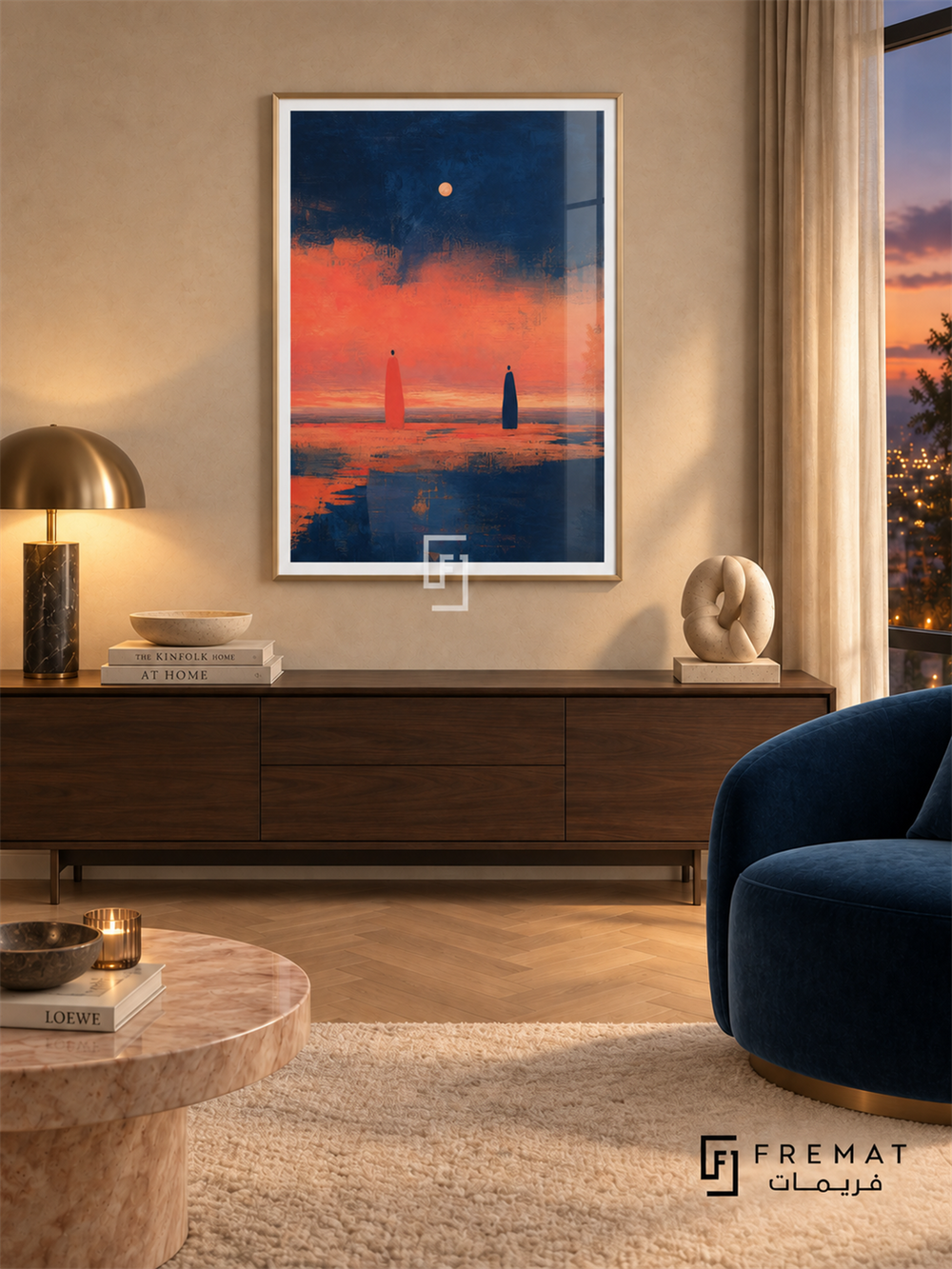 Evening Figures by FREMAT in a champagne gold PVC frame with a flat white printed border. Elegant twilight lounge: warm cream silk-texture wall, 155cm dark walnut lowboard, peacock-blue velvet chair right, blush stone table left, pale chevron parquet, soft indirect lighting and evening window glow.