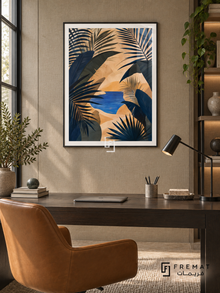 Oasis Leaves NAT10 by FREMAT in a slim matte black PVC frame, with an even white printed border, subtle glazing reflections and furniture showing scale.
