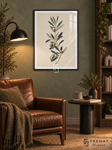 Olive Branch NAT12 by FREMAT in a slim matte black PVC frame, with an even white printed border, subtle glazing reflections and furniture showing scale.