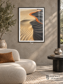 Sand Ripple NAT14 by FREMAT in a slim matte black PVC frame, with an even white printed border, subtle glazing reflections and furniture showing scale.