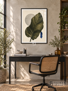 Leaf Study NAT15 by FREMAT in a slim matte black PVC frame, with an even white printed border, subtle glazing reflections and furniture showing scale.