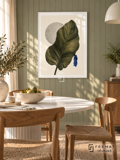 Leaf Study NAT15 by FREMAT in a slim satin white PVC frame, with an even white printed border, subtle glazing reflections and furniture showing scale.