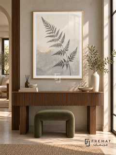Fern Silhouette NAT16 by FREMAT in a slim champagne gold PVC frame, with an even white printed border, subtle glazing reflections and furniture showing scale.