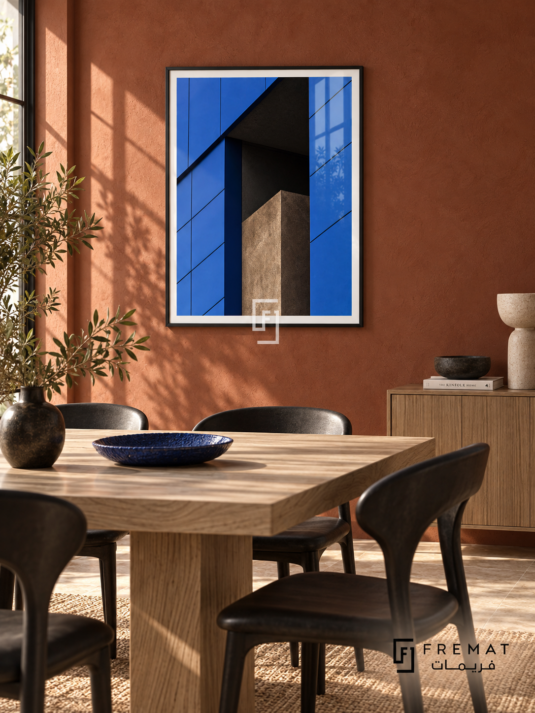 Blue Facade (PLC04) framed architectural wall art with a matte black PVC frame, flat white paper border and glass reflection. Modern dining room, clay-red plaster wall, bleached elm table 170cm.