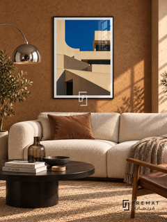 Terrace Forms (PLC09) framed architectural wall art with a matte black PVC frame, flat white paper border and glass reflection. Midcentury lounge, warm tobacco cork wall, cream sofa 170cm.