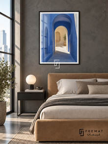 Passage Blue (PLC12) framed architectural wall art with a matte black PVC frame, flat white paper border and glass reflection. Tailored loft bedroom, charcoal-gray concrete wall, camel upholstered bed 160cm.
