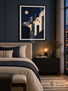 City Moon (PLC19) framed architectural wall art with a matte black PVC frame, flat white paper border and glass reflection. Urban night-blue bedroom, smoky blue wall panels, cream bed 165cm.