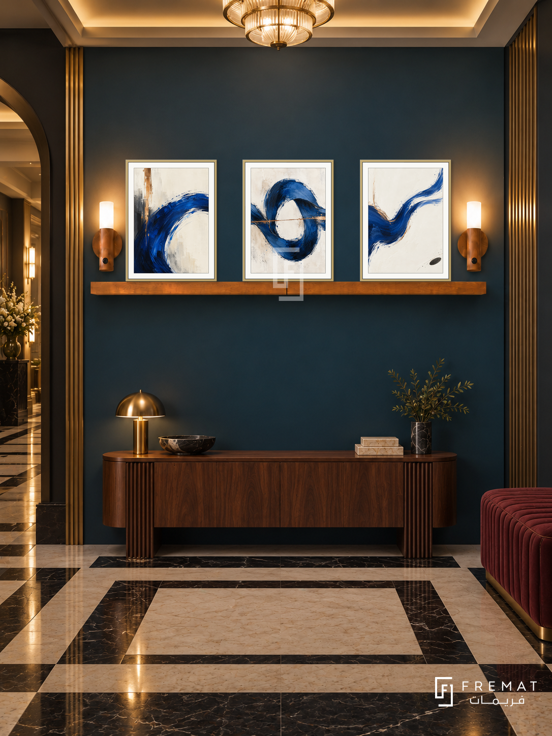 Cobalt Current shelf set, gold frames: three 30 x 40 cm artworks with equal 2 cm borders, honey wood 130 cm shelf and two upward warm sensor lamps. Art Deco foyer at night.
