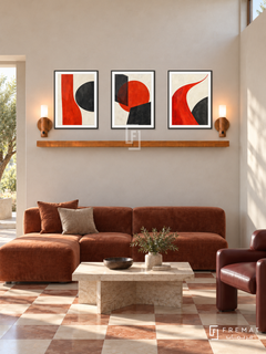 Vermilion Counterpoint shelf set in black frames, three 30 x 40 cm artworks with equal 2 cm borders, 130 cm honey wood shelf and two warm sensor lamps. Italian modernist reception in morning sunlight.