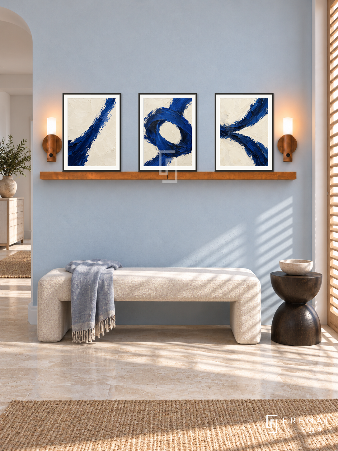 Ultramarine Tension complete shelf set in black frames: three 30 x 40 cm artworks with equal 2 cm borders, honey wood shelf and two sensor lamps. Coastal hallway in morning light.