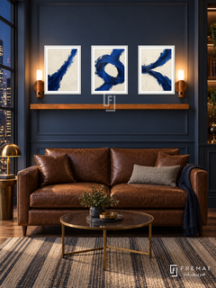 Ultramarine Tension complete shelf set in white frames: three 30 x 40 cm artworks with equal 2 cm borders, honey wood shelf and two sensor lamps. Navy study lounge at night.