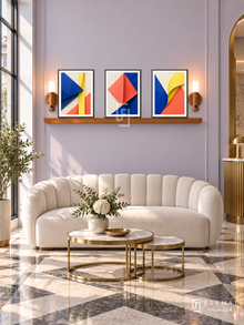 FREMAT SH-ABS21-BLK shelf set, three 30 x 40 cm artworks with 2 cm white mats, honey wood shelf and two upward sensor lamps. Morning Art Deco reception, pale lavender wall, cream scalloped sofa, brass nesting tables, geometric marble floor, tall window left.