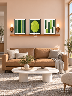 FREMAT SH-ABS24-BLK shelf set, three 30 x 40 cm artworks with 2 cm white mats, honey wood shelf and two upward sensor lamps. Morning Scandinavian peach lounge, pale peach wall, tan leather sofa, white oval table, wool grey rug, wide window right.