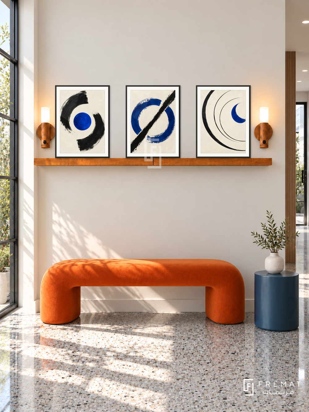 FREMAT SH-ABS26-BLK shelf set, three 30 x 40 cm artworks with 2 cm white mats, honey wood shelf and two upward sensor lamps. Morning graphic modern corridor, ivory wall, bright orange sculptural bench, blue cylindrical table, grey terrazzo floor, black steel window left.