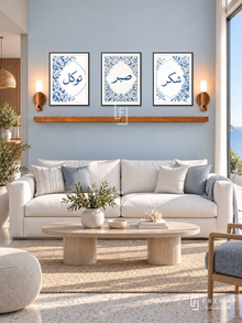 FREMAT Blue Garden shelf set with three 30 x 40 cm frames, 2 cm white borders, honey wood shelf and two warm sensor lamps. Morning coastal modern reception, muted sky-blue wall, white structured sofa, bleached oak oval coffee table, pale terrazzo floor, wide sea-facing window right.