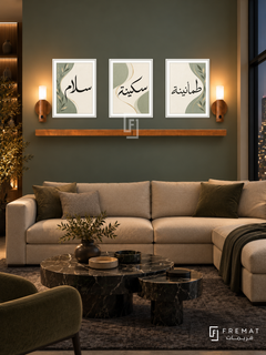 FREMAT Sage Ribbon shelf set with three 30 x 40 cm frames, 2 cm white borders, honey wood shelf and two warm sensor lamps. Night emerald contemporary living room, dusty green wall, angular beige sofa, nested dark marble tables, charcoal rug, tall dark window right, refined indirect ambient lighting.