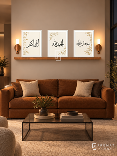 FREMAT Ivory Praise shelf set with three 30 x 40 cm frames, 2 cm white borders, honey wood shelf and two warm sensor lamps. Night warm minimalist living room, light putty wall, deep cognac low sofa, square smoked glass coffee table, pale wool rug, dark window right.
