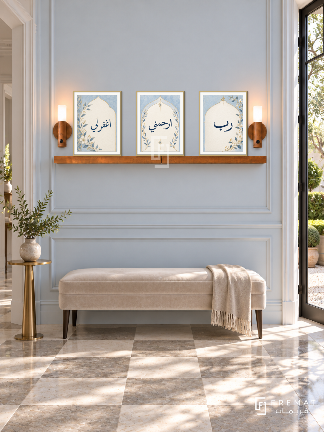 FREMAT Blue Prayer shelf set with three 30 x 40 cm frames, 2 cm white borders, honey wood shelf and two warm sensor lamps. Morning classic ivory hallway, pale blue moulded wall, beige velvet bench, brass slim pedestal, checkerboard limestone tiles, garden doorway right.