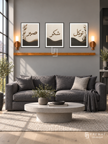 FREMAT Charcoal Linen shelf set with three 30 x 40 cm frames, 2 cm white borders, honey wood shelf and two warm sensor lamps. Morning modern graphite living room, warm grey wall, charcoal linen sofa, light concrete oval table, pale oak flooring, broad industrial window left.