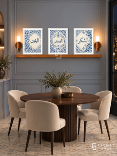 FREMAT Porcelain Devotion shelf set with three 30 x 40 cm white frames, 2 cm white borders, honey wood shelf and two warm sensor lamps. Night French contemporary dining alcove, dove grey-blue panelled wall, dark walnut circular table, ivory velvet chairs, pale patterned tile floor, dark window right.