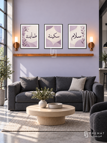 FREMAT Lilac Peace shelf set with three 30 x 40 cm black frames, 2 cm white borders, honey wood shelf and two warm sensor lamps. Morning modern loft lounge, pale lilac wall, charcoal low sofa, rounded pale oak table, concrete floor, industrial window left.
