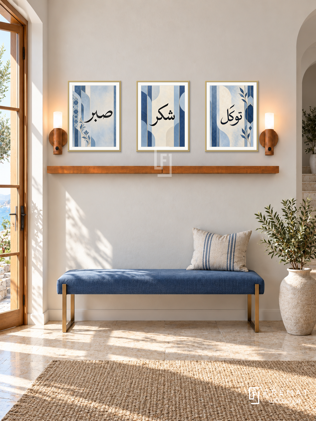 FREMAT Soft Cobalt shelf set with three 30 x 40 cm gold frames, 2 cm white borders, honey wood shelf and two warm sensor lamps. Morning elegant coastal entrance, pale ivory wall, soft cobalt upholstered bench, brass console leg details, light limestone floor, sunny doorway left.